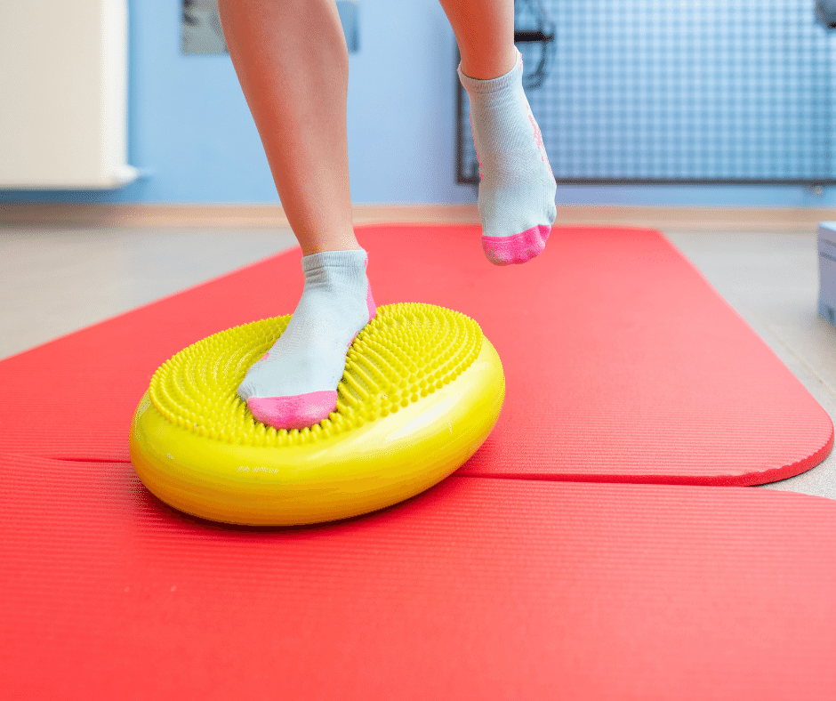 person standing on one leg on an yellow balancing ball